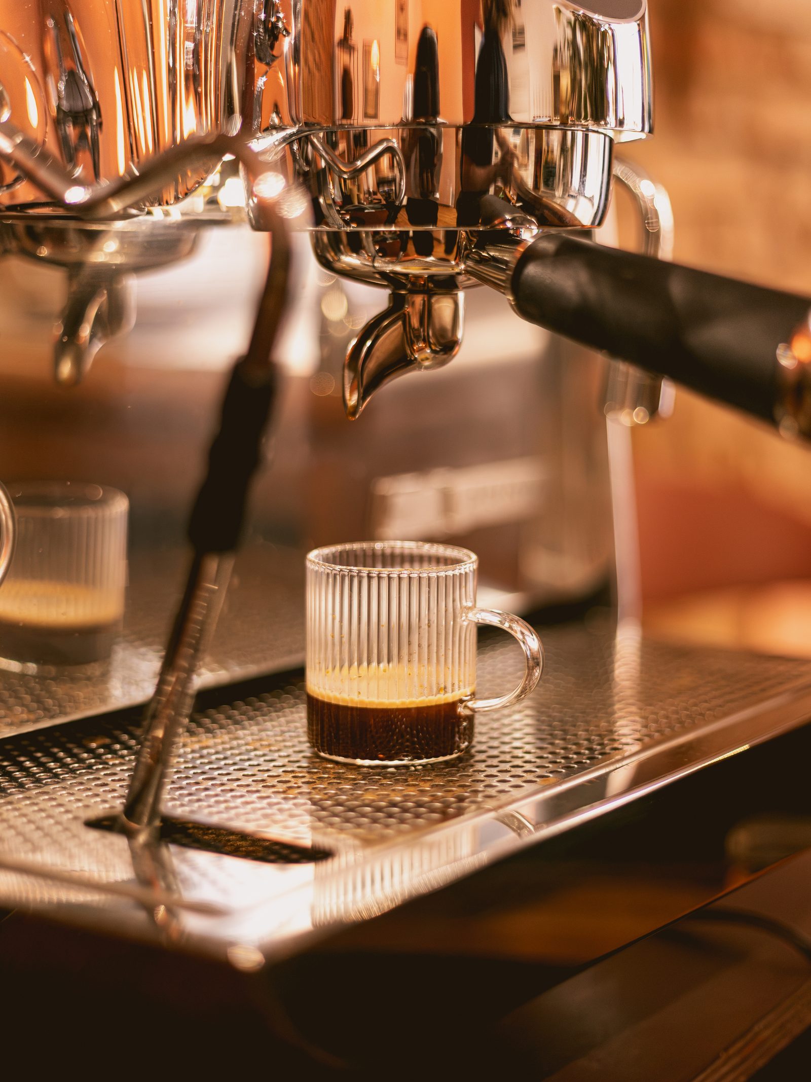 Un espresso qui coule dans un verre strié sous la machine