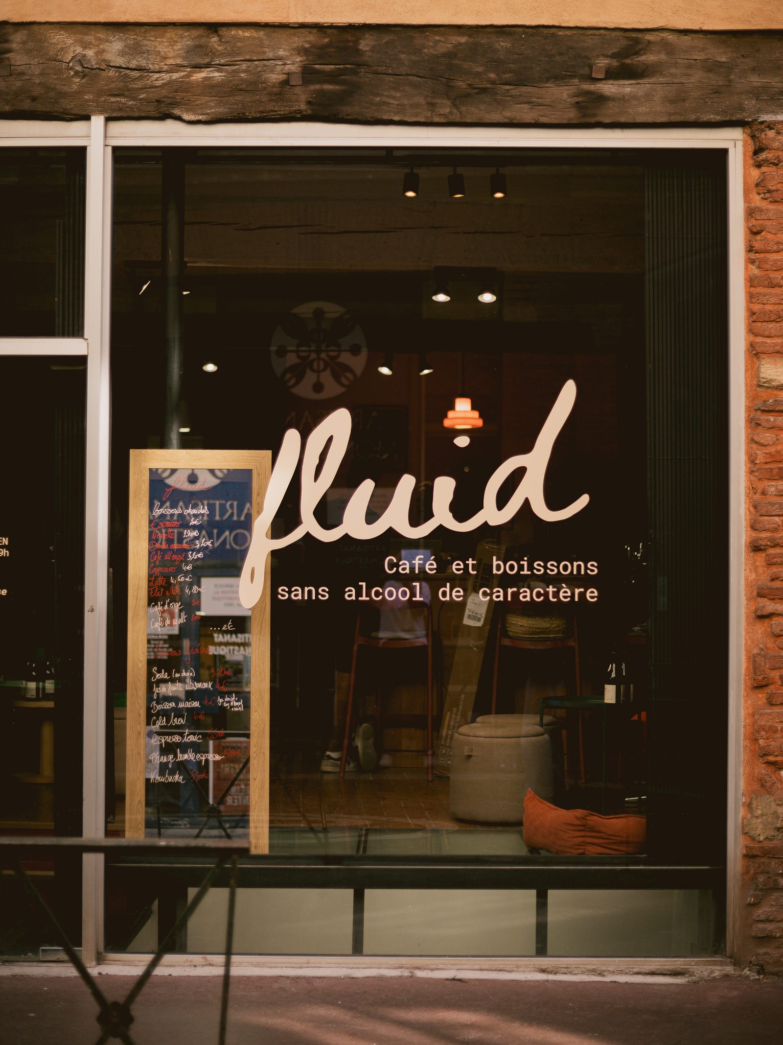 La vitrine de Fluid rue Pierre de Fermat, le logo fluid peint sur la vitre, l'intérieur éclairé